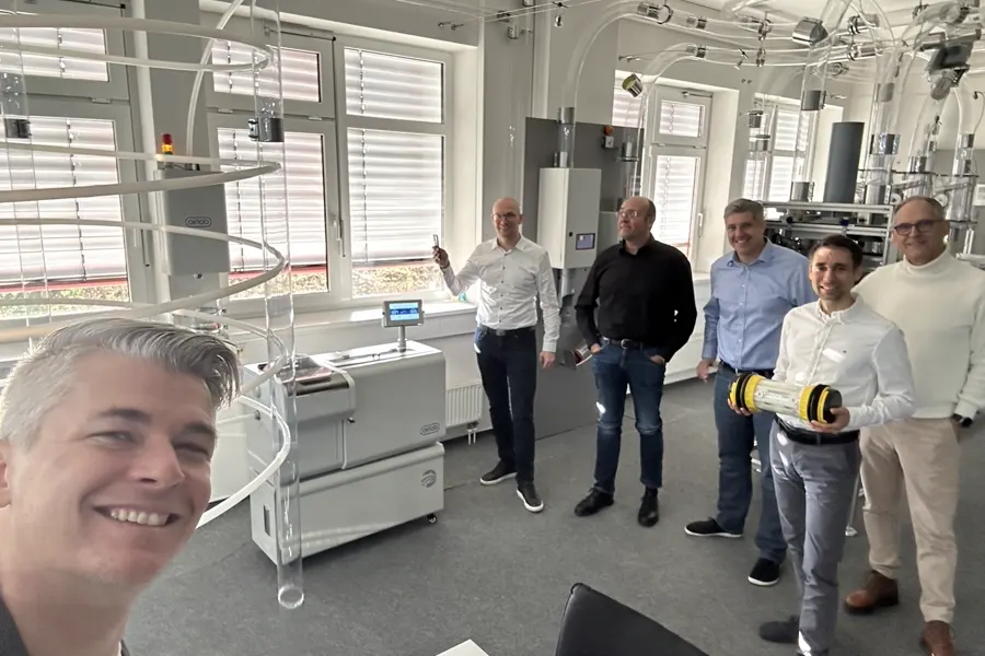 Mehrere Personen im Showroom von Aerocom neben einer Transportanlage
